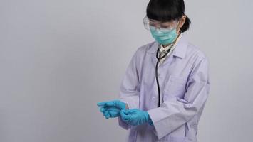 usando guantes. El médico asiático usa guantes de manos de nitrilo de goma azul.
