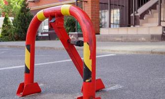 Manual red metal parking barrier with lock. Parking lock device. photo