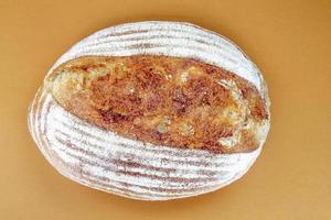 Freshly baked organic sourdough bread isolated on brown photo