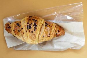 One regular fresh crispy whole grain croissant with chocolate filling photo