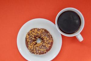 una rosquilla de chocolate y café americano negro sin leche foto