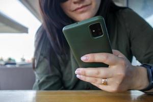 Close up of woman's hand with wedding ring holding cell or phone photo