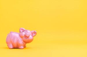 Piggy bank, saving money concept against yellow background photo