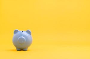 Piggy bank, saving money concept against yellow background photo