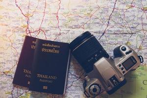 pasaporte de tailandia y cámara en el mapa para viajes mundiales foto