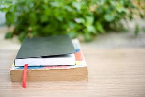 Old book on  wooden table at home garden with nature bokeh background photo