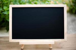 Black board on wood table top Template mock up for display of product photo