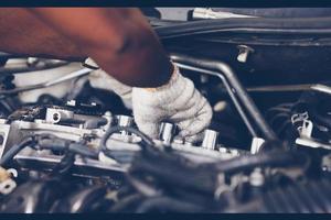 Hands of auto mechanic repairing car. Selective focus.