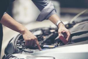 hombre revisando el motor de un coche foto