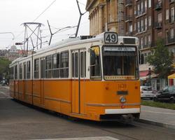 Orange electric tram running through the city of Budapest photo