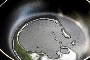 Hot cooking oil in the black cooking pan photo