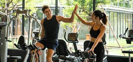 parejas jóvenes hacen ejercicio en el gimnasio para fortalecer el cuerpo foto