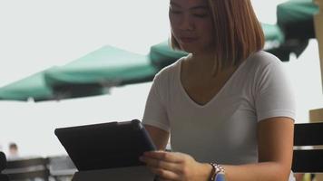 junge asiatische Frau kreativer Designer mit Tablet im Café. video