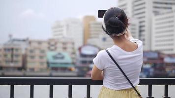 mujer asiática que tiene video chat mostrando vista y compartiendo con amigos.