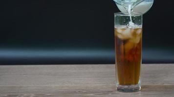 milk was poured into glass of tea served on table in cafe video