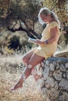 A barefoot blonde woman in a yellow summer dress photo