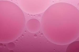 Water and oil, color abstract background based on pink, rose color circles and ovals, macro abstraction, real photo. photo