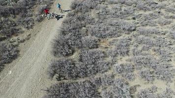 foto aérea de uma trilha de jovem e mulher correndo com o cachorro na trilha cênica da montanha. video