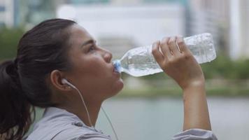 Close up portrait young asian woman runner drink water after running. Sports woman running healthy lifestyle.