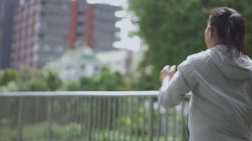 mooie jonge aziatische vrouw runner training in zomer park. sportvrouw met een gezonde levensstijl. video