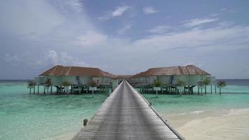 praia tropical e mar com bangalô nas maldivas
