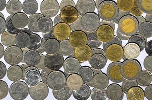 Moneda de dinero en aumento de monedas de baht tailandés de plata y oro gráficos con reflexión aislado sobre fondo blanco pilas de monedas sobre un fondo blanco. foto