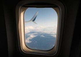 Vista panorámica de la luz del sol a través de la ventana del avión en el cielo foto