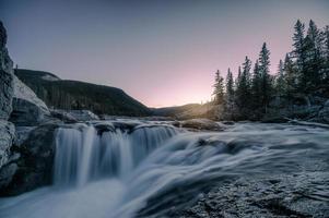 Waterfall rapids flowing on rocks in pine forest on evening at Elbow falls