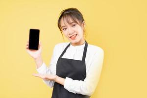 Portrait of cheerful waitress on yellow background photo