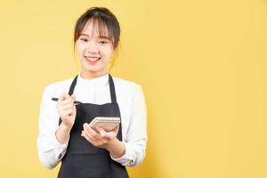 Portrait of cheerful waitress on yellow background photo