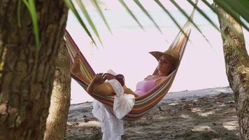 mujer sentada en una hamaca leyendo un libro, costa rica. filmado en rojo épico para una resolución de alta calidad de 4k, uhd, ultra hd. video