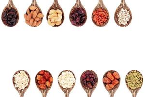 Top view group of whole grains and dried fruits 12 kinds on wooden spoons with copy space isolated on white background. photo