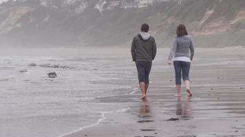 casal caminhando na praia juntos. filmado em vermelho épico para alta qualidade 4k, uhd, resolução ultra hd. video