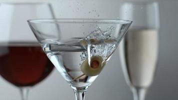 Zeitlupenaufnahme von Oliven, die in Martini spritzen, aufgenommen auf Phantom Flex 4k bei 1000 fps video