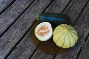 Gmo free melons and zucchini on a wooden table from directly above photo