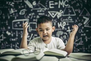 Boys with glasses write books and think in the classroom photo