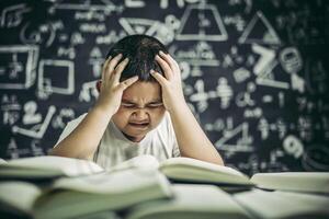 Boys with glasses write books and think in the classroom photo