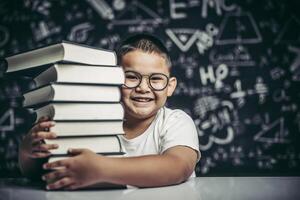 A boy hugging a pile of books. photo