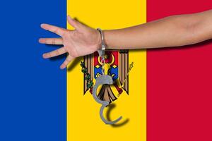 handcuffs with hand on Moldova flag photo