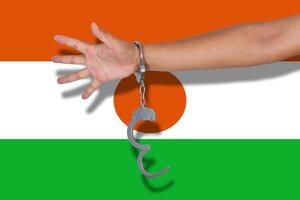 handcuffs with hand on Niger flag photo