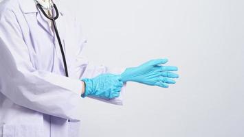 usando guantes. El médico asiático usa guantes de manos de nitrilo de goma azul. foto