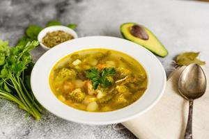 Tasty vegetables and spices soup on a gray concrete background. It can be used as a background photo