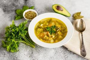 Tasty vegetables and spices soup on a gray concrete background. It can be used as a background photo