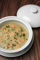 German traditional KARTOFFELSUPPE potato and sausage soup on wood table photo