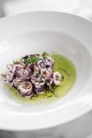 Ensalada de calamar marinado con mariscos frescos tradicionales portugueses en aceite de cilantro