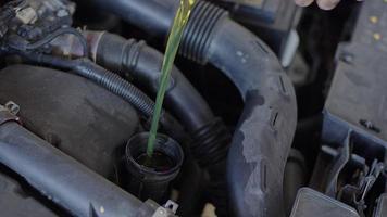 motor van een auto gieten olie in werkplaats garage video