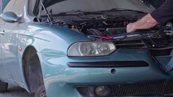 reparatör reparerar motorn på en trasig bil på bilverkstaden video