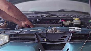 reparador conserta motor de carro quebrado em oficina mecânica video