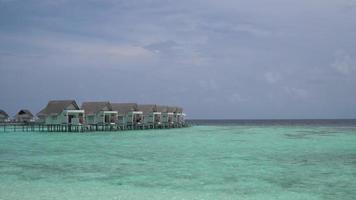 plage tropicale et mer avec bungalow aux maldives video