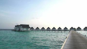 tropisch strand en zee met bungalow in maldiven video